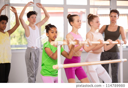 Teenage girls practicing plie position of ballet during choreography classes Teenage girls practicing plie position of ballet during choreography classes 114789980