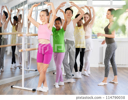 Teen girl mastering fifth position in beginner ballet class Teen girl mastering fifth position in beginner ballet class 114790038