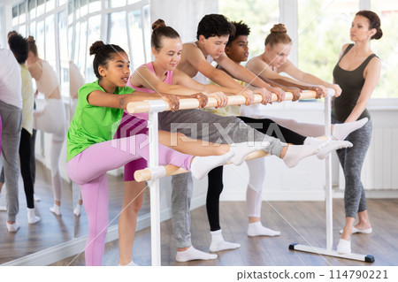 African american teen girl stretching at barre at group ballet class 114790221
