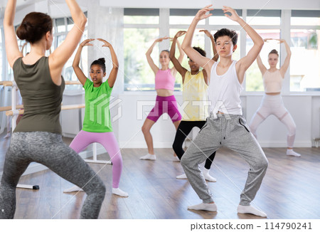Teenager participating in beginner group ballet class in choreography studio 114790241