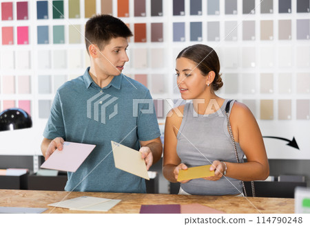 Married couple discussing ceramic tile colors in hardware store 114790248
