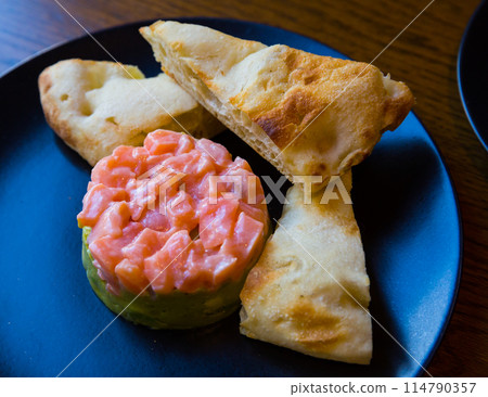 Salmon tartare with guacamole and toasts 114790357