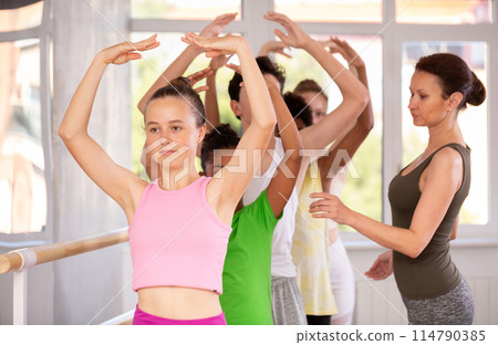 Teenage girl practicing ballet positions in dance studio Teenage girl practicing ballet positions in dance studio 114790385