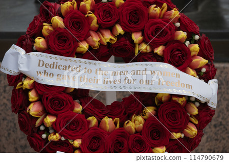 Flower wreath at American cemetery monumnent at Normandy area. WWII memorial. Lines of grave stones with american flag. High quality photo Flower wreath at American cemetery monumnent at Normandy area. WWII memorial. Lines of grave stones with american flag. High quality photo 114790679
