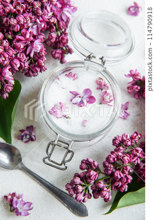 Natural Lilac Sugar in a Glass Jar Surrounded by Fresh Lilac Blooms Natural Lilac Sugar in a Glass Jar Surrounded by Fresh Lilac Blooms 114790918