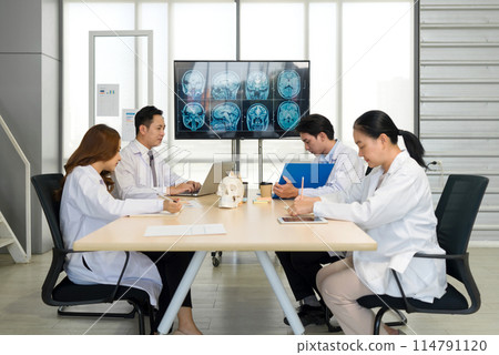 Group of medical professional engaged in a discussion or meeting in a medical office. A large monitor displaying multiple MRI brain scans, to revolve around patient diagnosis and treatment planning. 114791120