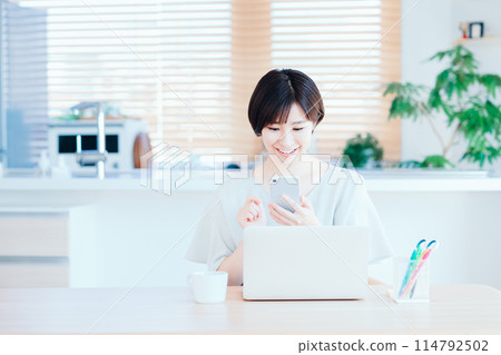 A housewife working remotely in the living room. 114792502