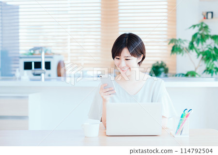 A housewife working remotely in the living room. A housewife working remotely in the living room. 114792504