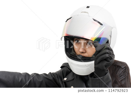A girl on a motorcycle opens the shield of her full-face helmet 114792923