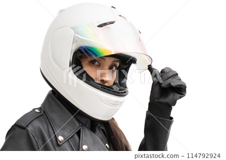 A girl on a motorcycle opens the shield of her full-face helmet 114792924