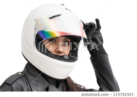 A girl on a motorcycle closes the shield of her full-face helmet 114792925