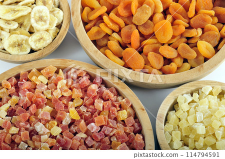 Dried and candied fruits in wooden bowls Dried and candied fruits in wooden bowls 114794591