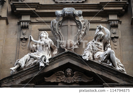 Statues of Hope and Poverty seated either side of the arms of the Theatine order over the central door on the facade of Santi Michele e Gaetano church in Florence, Italy Statues of Hope and Poverty seated either side of the arms of the Theatine order over the central door on the facade of Santi Michele e Gaetano church in Florence, Italy 114794875