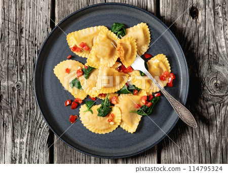 italian pasta mezzelune on a plate, top view 114795324