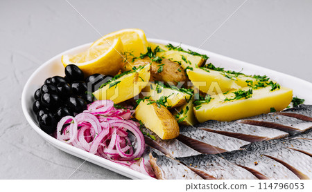 Traditional marinated herring plate with garnishes 114796053