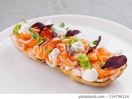 Gourmet smoked salmon bruschetta on white plate 114796124