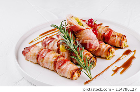 Bacon-wrapped stuffed jalapenos on plate Bacon-wrapped stuffed jalapenos on plate 114796127
