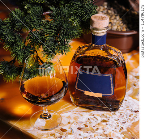 Festive brandy and glass by christmas tree 114796178