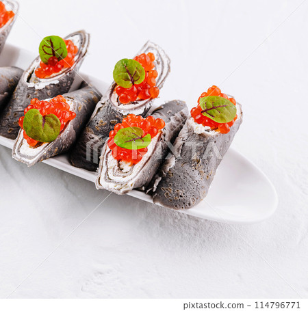 Gourmet black crepe rolls with red caviar 114796771