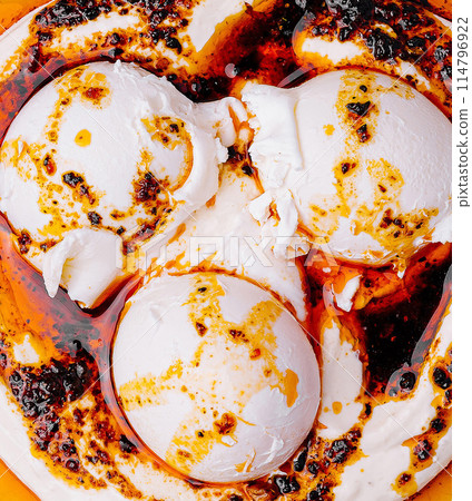 Gourmet poached eggs with spicy sauce closeup Gourmet poached eggs with spicy sauce closeup 114796922
