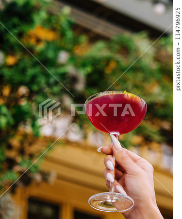 Elegant hand holding cocktail outdoors 114796925