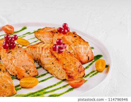 Grilled salmon fillets with berries and pesto sauce Grilled salmon fillets with berries and pesto sauce 114796946