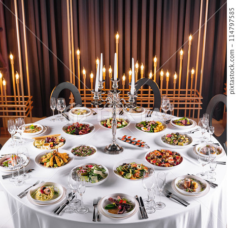 Elegant dinner table with gourmet dishes and candlelight 114797585