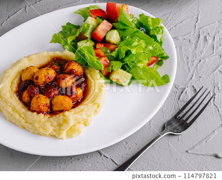 plate of nutritious meals with salad, grilled cutlet, and mashed potatoes on a stone background plate of nutritious meals with salad, grilled cutlet, and mashed potatoes on a stone background 114797821