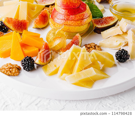 Gourmet cheese and fruit platter on white background 114798428