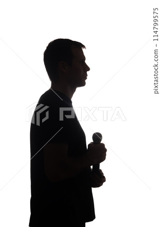 Young man with microphone in his hands - silhouette Young man with microphone in his hands - silhouette 114799575