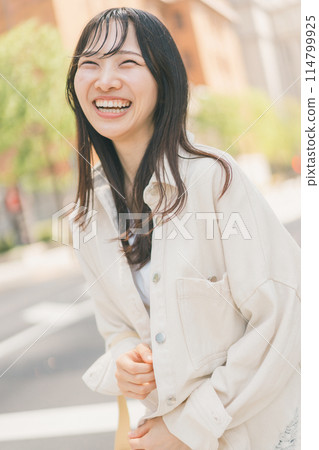 一位年輕女子度假時在城市裡散步 114799925