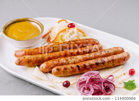 Grilled sausages with sauces and salad on plate Grilled sausages with sauces and salad on plate 114800066
