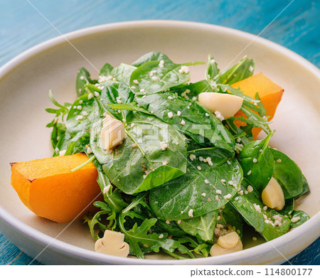Fresh spinach and pumpkin salad on ceramic plate 114800177