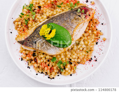 Grilled salmon fillet with herb couscous on plate 114800178