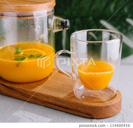 Freshly blended orange smoothie in glass and pitcher 114800458