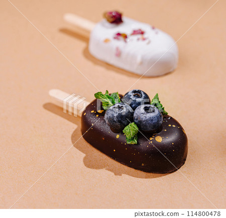 Gourmet ice cream popsicles with berries and chocolate glaze Gourmet ice cream popsicles with berries and chocolate glaze 114800478