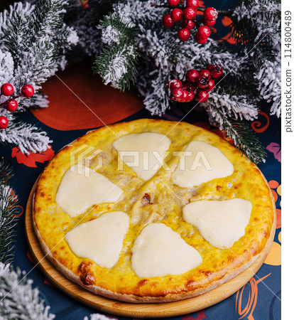 Festive cheese pizza under christmas tree 114800489