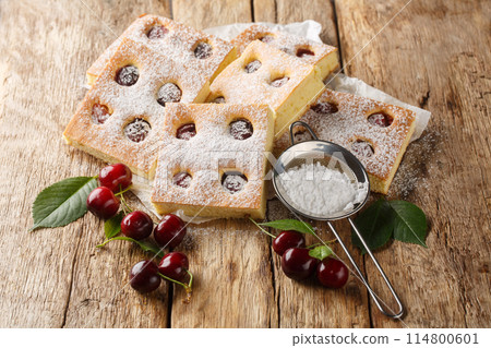 Czech bublanina cherry cake with sprinkled with powdered sugar closeup on the parchment. Horizontal Czech bublanina cherry cake with sprinkled with powdered sugar closeup on the parchment. Horizontal 114800601