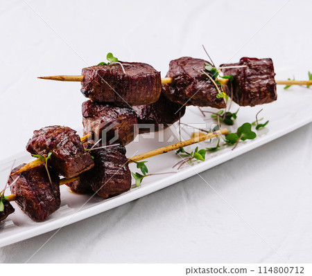 Gourmet grilled steak skewers on white plate Gourmet grilled steak skewers on white plate 114800712