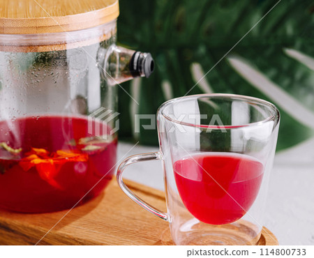 Freshly brewed hibiscus tea in glass teapot and cup Freshly brewed hibiscus tea in glass teapot and cup 114800733