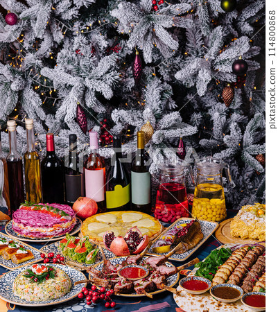 Festive holiday feast with decorated christmas tree 114800868