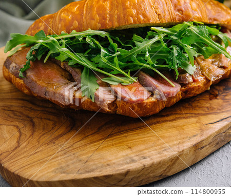 Gourmet croissant sandwich with arugula and ham Gourmet croissant sandwich with arugula and ham 114800955