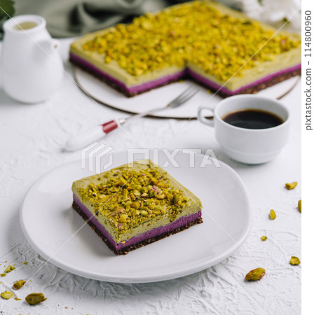 Pistachio cake slice with coffee on a white table Pistachio cake slice with coffee on a white table 114800960