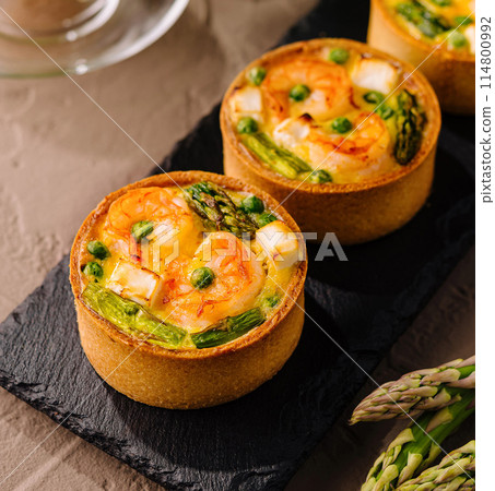 Savory mini quiches with asparagus and orange juice 114800992