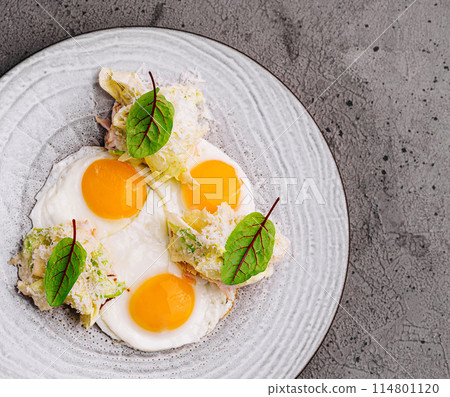 Gourmet breakfast plate with poached eggs and greens 114801120
