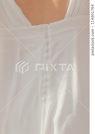 Buttons on the back of a wedding dress 114801764