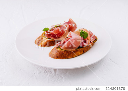 Elegant prosciutto bruschetta on white plate 114801878
