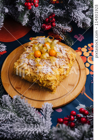 Festive napoleon cake on wooden platter with christmas decor Festive napoleon cake on wooden platter with christmas decor 114801928