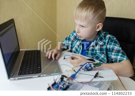 Programming for children. The boy is studying online at a robotics school for programming courses. Child learning control board coding 114802233