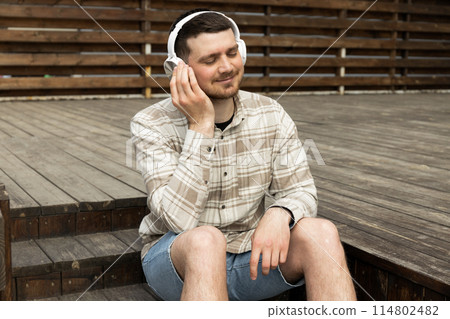 Attractive young guy listens to music in headphones 114802482